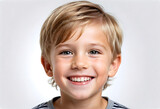 White background photo of professional portrait of cute blond Caucasian boy child model smiling with perfect clean teeth. For advertising, web design, etc.
