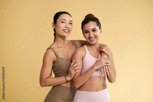 Portrait diverse happy female friends in sports bra and leggings