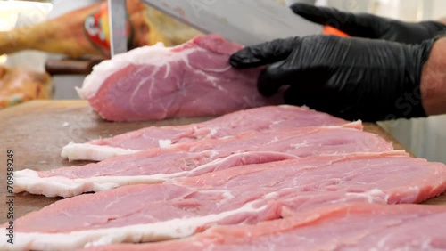 il Macellaio taglia le fettine di carne di vitella.
il coltello affilato prepara la carne per la vendita. photo