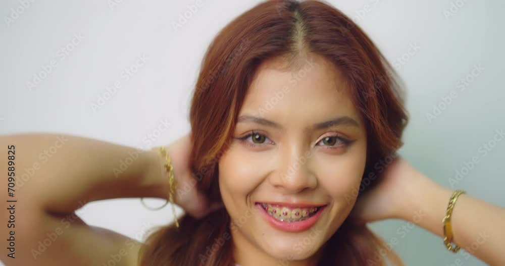 Happy beautiful asian girl with braces. She looking to camera with attractive smiling at white background.