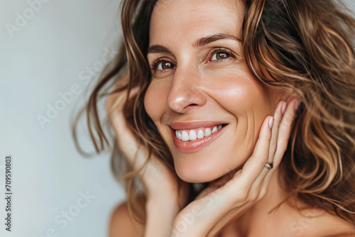 Mature Woman With Radiant Smile Examines Her Healthy, Pampered Skin