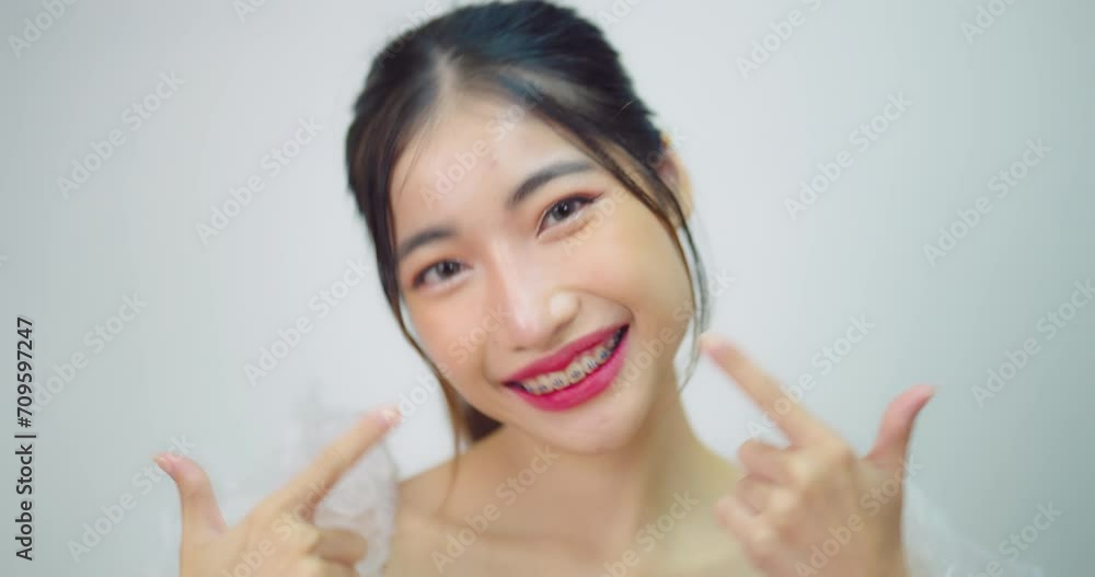 Happy beautiful asian girl with braces. She looking to camera with attractive smiling at white background. Happy beautiful asian girl with braces. She looking to camera with attractive smiling at white background.