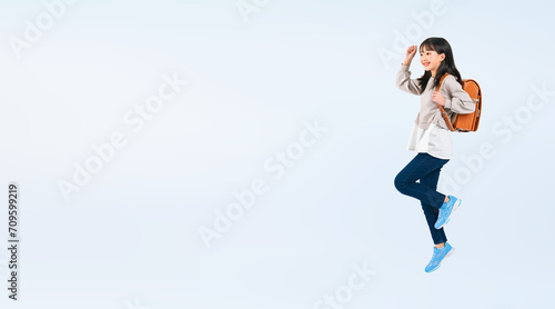 ランドセルを背負ってジャンプする女子小学生（切り抜き背景透過PNGも販売しております。作成者リンクから「PNG」で検索してください） photo