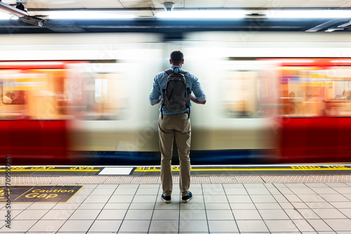 Businessman waiting for train on subway platform photo