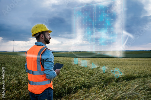 Engineer looking at digital solar panel design over field photo