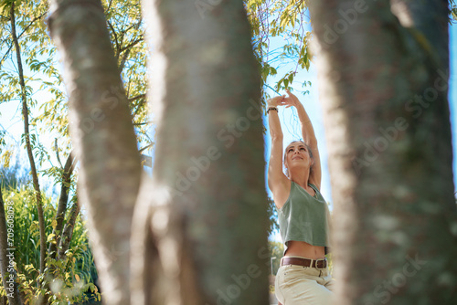 Woman with arms stretched standing near trees