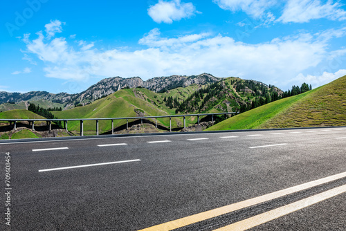 Asphalt road and mountain nature landscape under blue sky