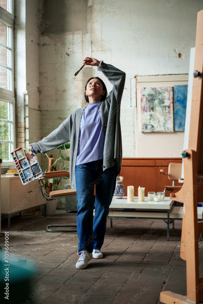 Painter dancing with palette and paintbrush at studio Painter dancing with palette and paintbrush at studio