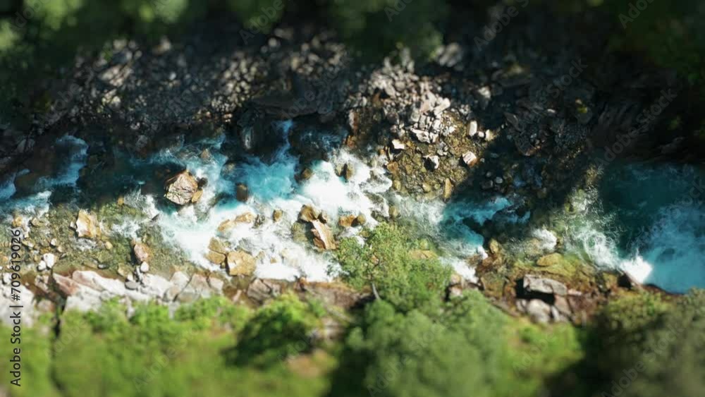A shallow mountain river rushes through the rocky canyon. Aerial view. A shallow mountain river rushes through the rocky canyon. Aerial view.