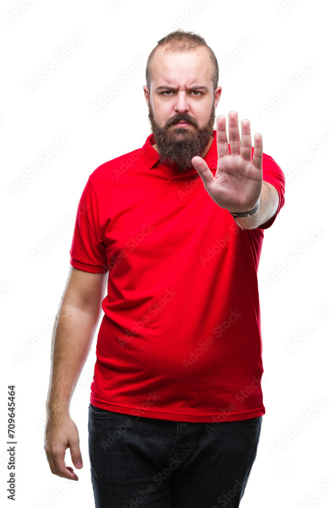 Young caucasian hipster man wearing red shirt over isolated background doing stop sing with palm of the hand. Warning expression with negative and serious gesture on the face. Young caucasian hipster man wearing red shirt over isolated background doing stop sing with palm of the hand. Warning expression with negative and serious gesture on the face.