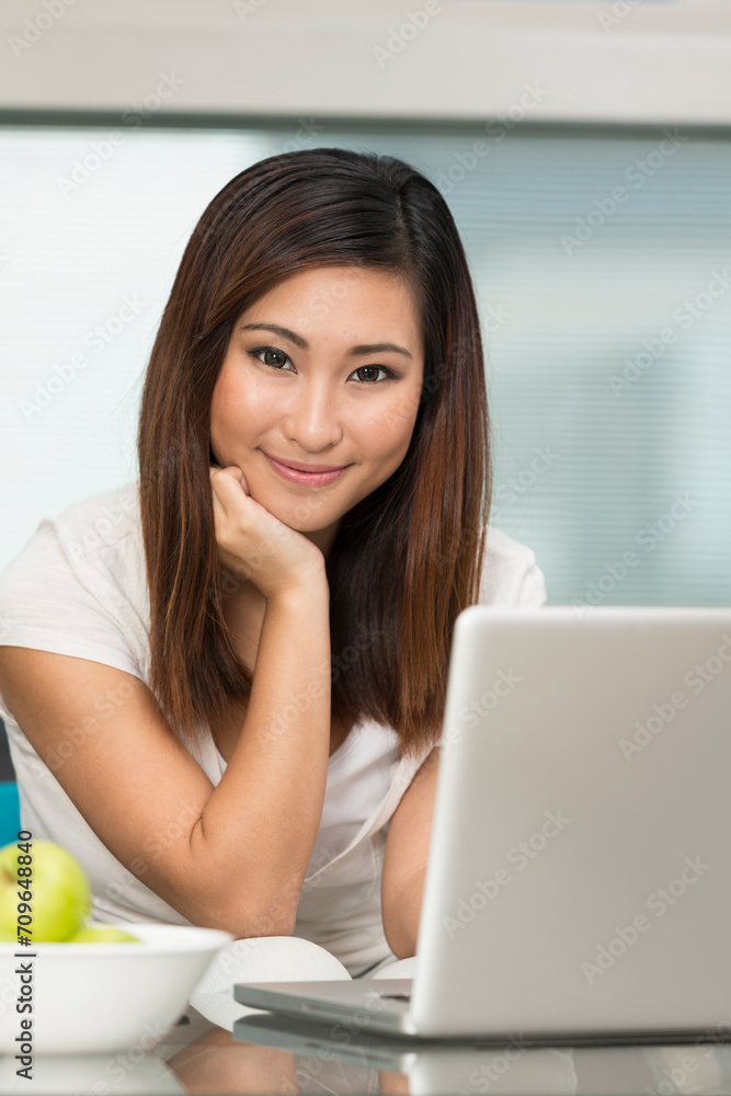 Asian woman at home working on a laptop Asian woman at home working on a laptop