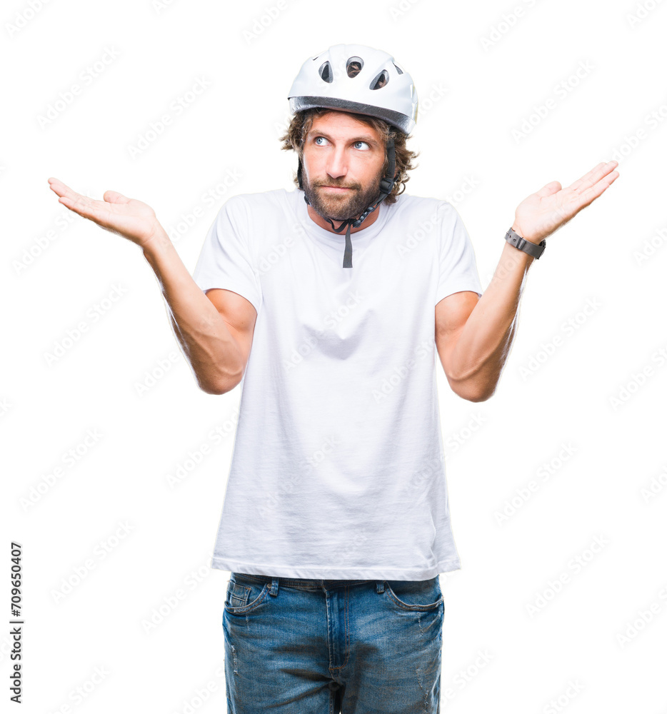 Handsome hispanic cyclist man wearing safety helmet over isolated background clueless and confused expression with arms and hands raised. Doubt concept. Handsome hispanic cyclist man wearing safety helmet over isolated background clueless and confused expression with arms and hands raised. Doubt concept.