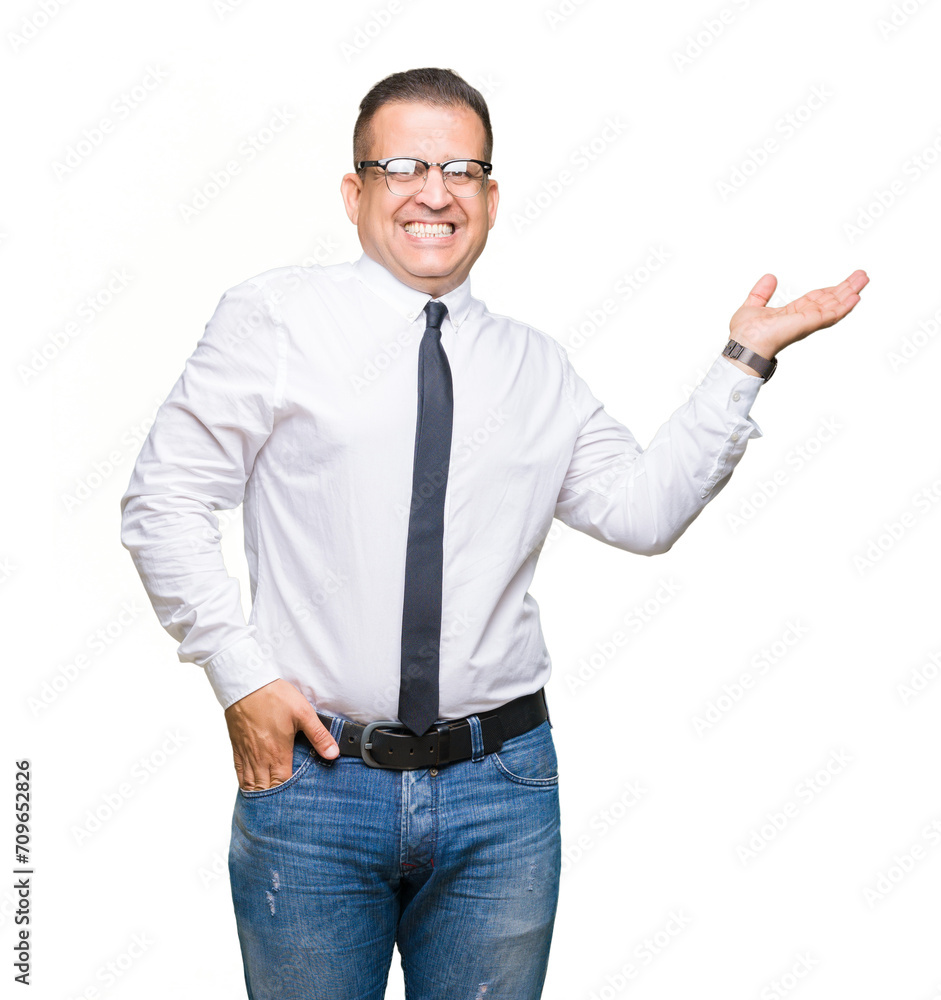 Middle age bussines arab man wearing glasses over isolated background smiling cheerful presenting and pointing with palm of hand looking at the camera. Middle age bussines arab man wearing glasses over isolated background smiling cheerful presenting and pointing with palm of hand looking at the camera.