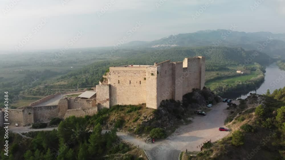 Miravet Castle atop hill. Drone moves away to open panoramic shot Miravet Castle atop hill. Drone moves away to open panoramic shot