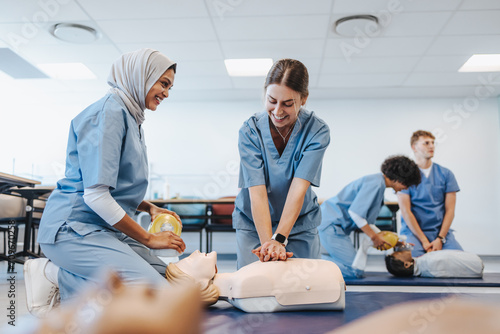 Happy medical students undergoing CPR training in clinical simulation photo