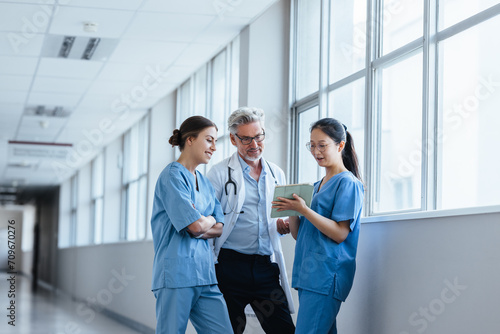 Young medical interns discussing with a senior doctor in a teaching hospital photo