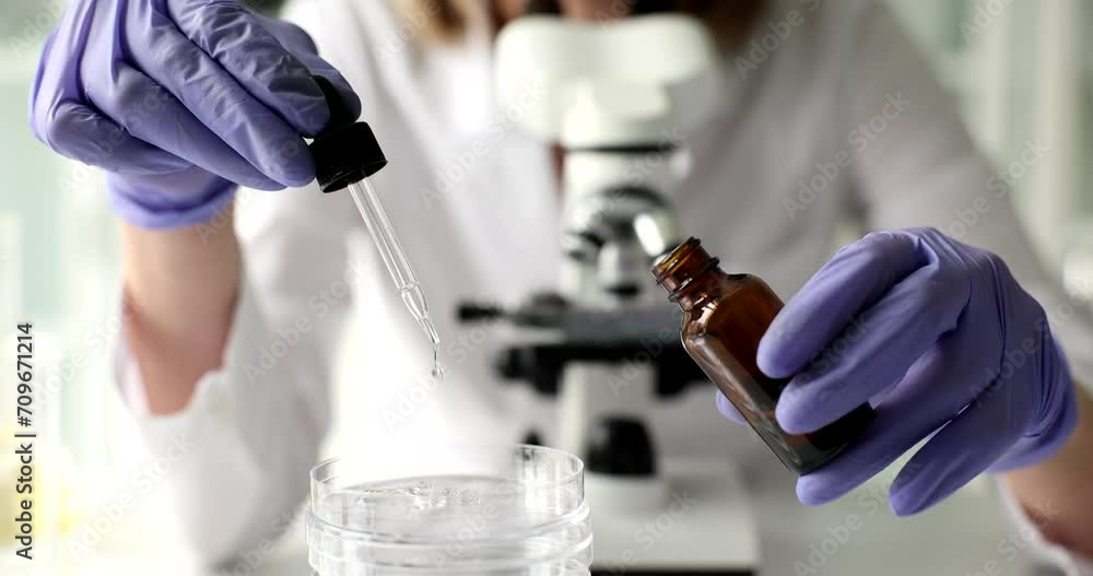 Pharmacist opens dropper with drop of natural oil over glass bottle. Laboratory testing of cosmetics and moisturizing