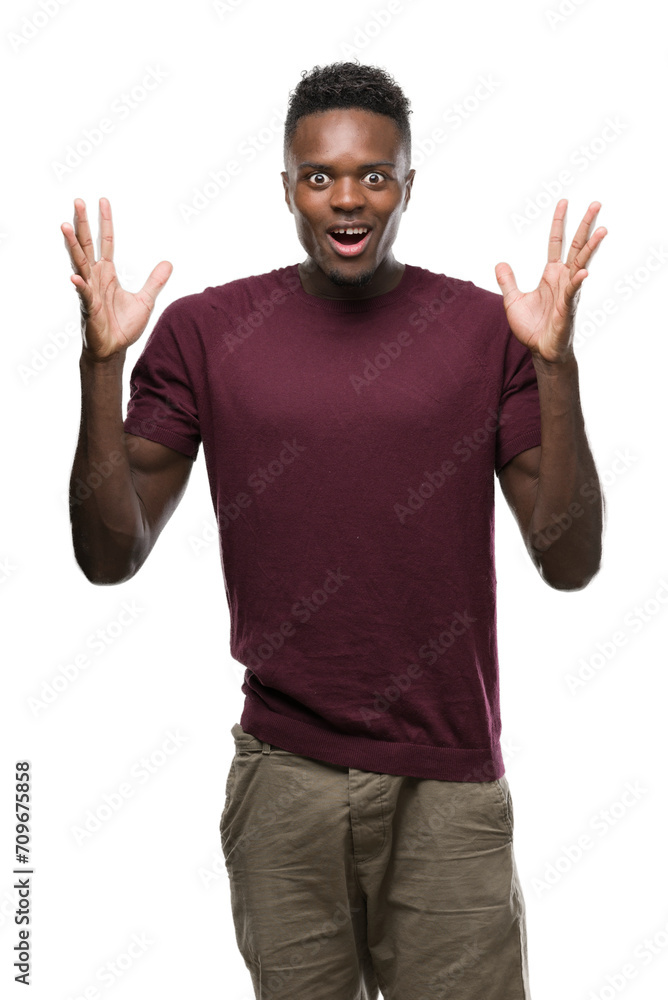 Young african american man very happy and excited, winner expression celebrating victory screaming with big smile and raised hands Young african american man very happy and excited, winner expression celebrating victory screaming with big smile and raised hands