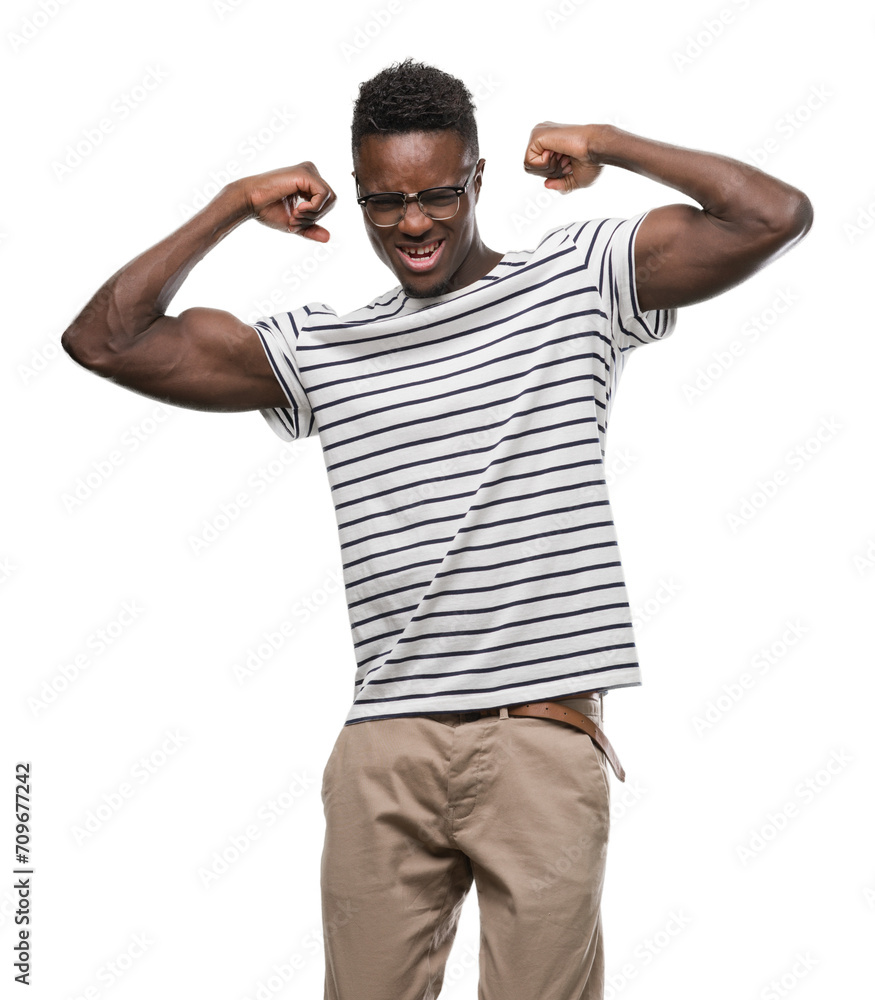 Young african american man wearing glasses and navy t-shirt showing arms muscles smiling proud. Fitness concept. Young african american man wearing glasses and navy t-shirt showing arms muscles smiling proud. Fitness concept.