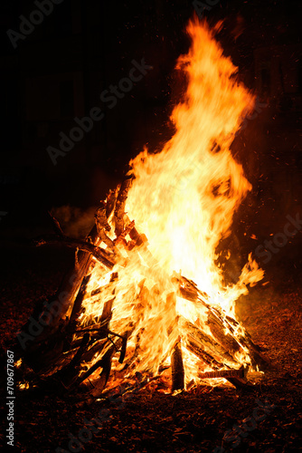 Bonfire burning at night, bright orange flames of fire, selective focus
