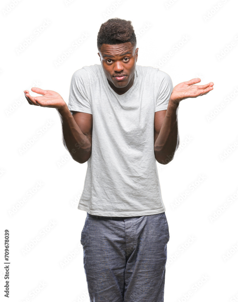 Young african american man over isolated background clueless and confused expression with arms and hands raised. Doubt concept. Young african american man over isolated background clueless and confused expression with arms and hands raised. Doubt concept.