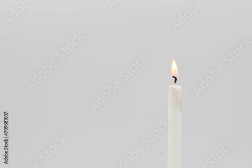 white burning candle on a white background
