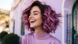 Carefree young woman with a bright smile and short curly purple hair, wearing a pink turtleneck, enjoying a sunny day outdoors.