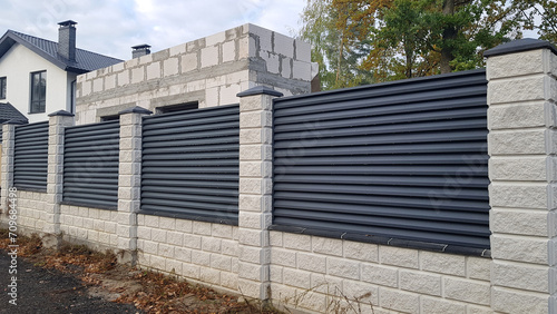 Modern stone fence with metal shutters photo