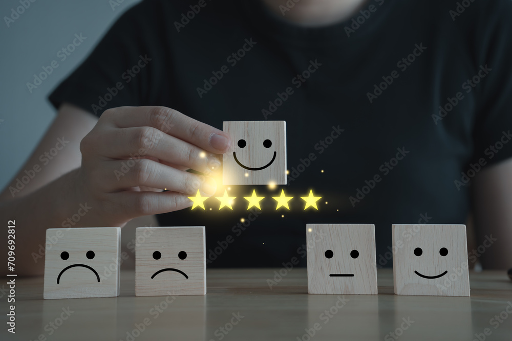 Woman hand choosing happy smiling face and 5 star on wooden block. Feedback rating and Customer experience, World mental health day, Think positive, Emotion, Satisfaction score concept. - obrazy, fototapety, plakaty 