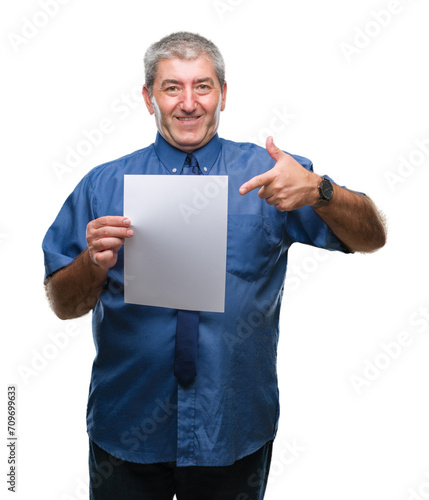 Handsome senior man holding blank sheet paper over isolated background very happy pointing with hand and finger