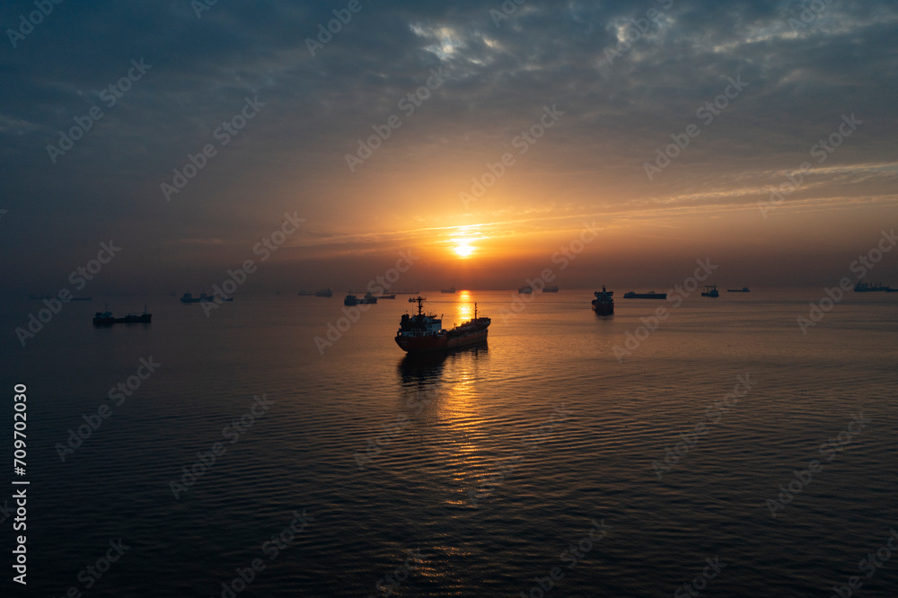 Ships waiting at sea at sunset