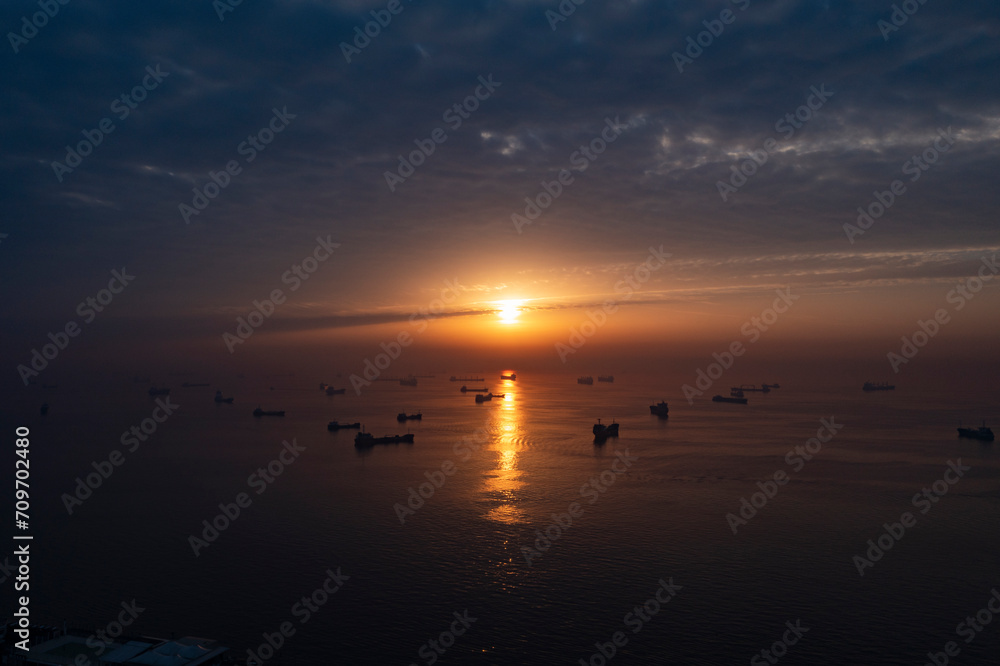 Ships waiting at sea at sunset