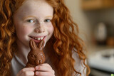 little funny red-haired girl wants to eat the Easter chocolate bunny