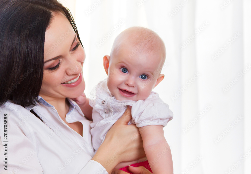 Happy smiling mother with six month old baby girl