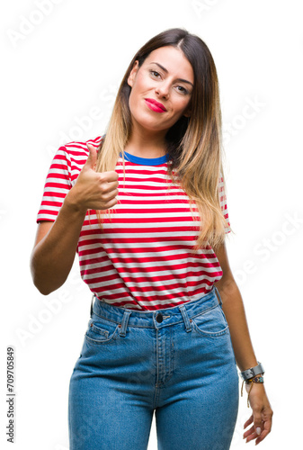 Young beautiful woman casual look over isolated background doing happy thumbs up gesture with hand. Approving expression looking at the camera with showing success.