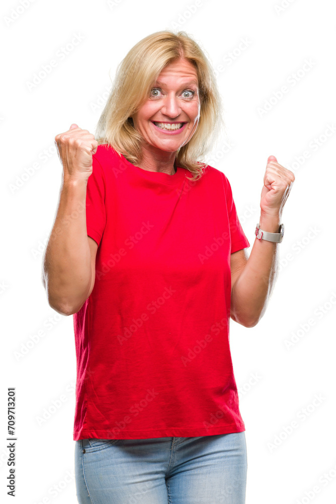 Middle age blonde woman over isolated background very happy and excited doing winner gesture with arms raised, smiling and screaming for success. Celebration concept. Middle age blonde woman over isolated background very happy and excited doing winner gesture with arms raised, smiling and screaming for success. Celebration concept.