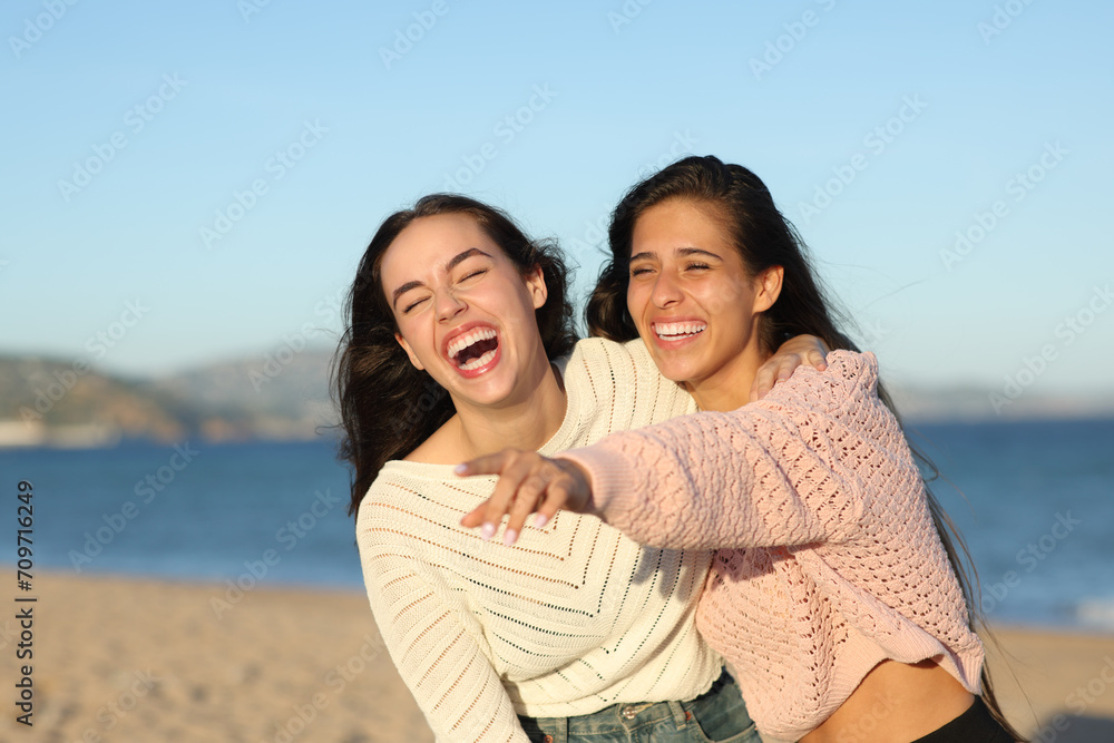 Happy friends pointing away and lahghing loud Happy friends pointing away and lahghing loud