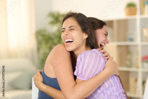 Happy friends hugging at home photo