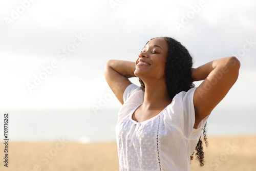 Joyful black woman breathing on the beach photo
