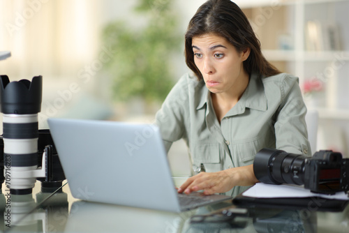 Perplexed photographer working online at home photo