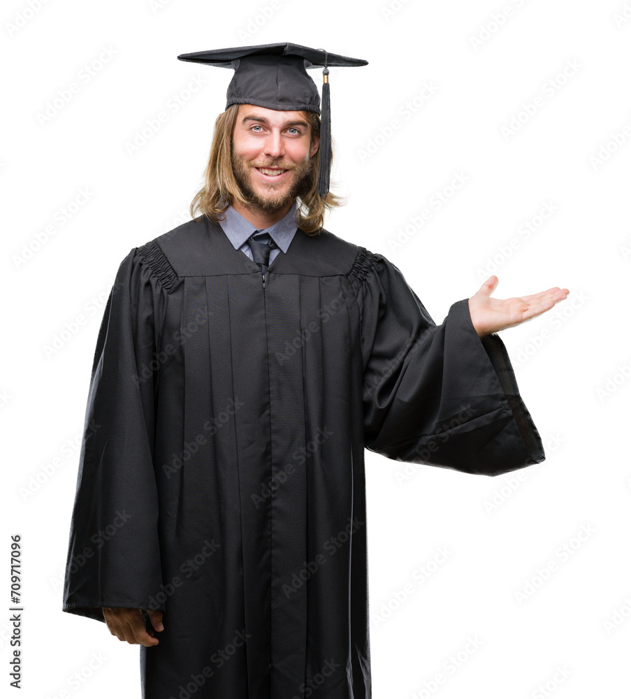 Young handsome graduated man with long hair over isolated background smiling cheerful presenting and pointing with palm of hand looking at the camera. Young handsome graduated man with long hair over isolated background smiling cheerful presenting and pointing with palm of hand looking at the camera.