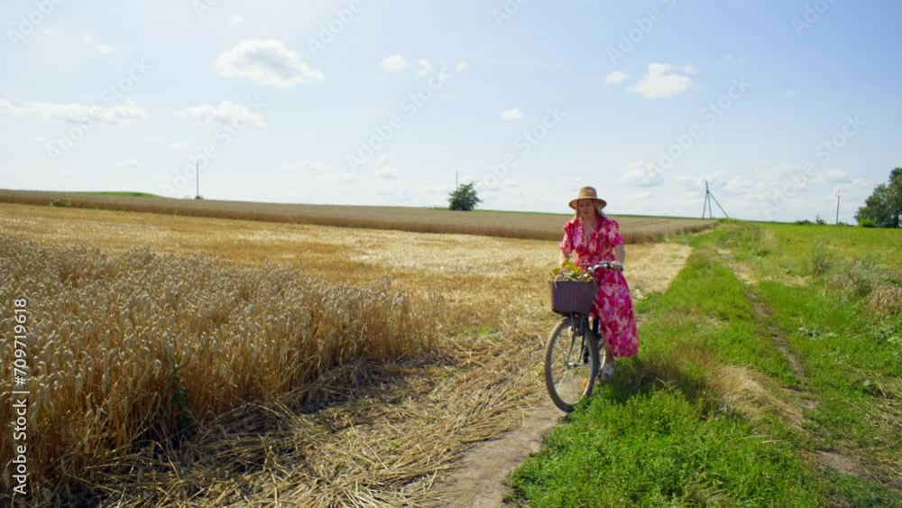 A woman on a bicycle in a good mood throws away her hat. It is difficult for her to cope with the management of transport. The beauty of nature opens up around her. High quality 4k footage A woman on a bicycle in a good mood throws away her hat. It is difficult for her to cope with the management of transport. The beauty of nature opens up around her. High quality 4k footage