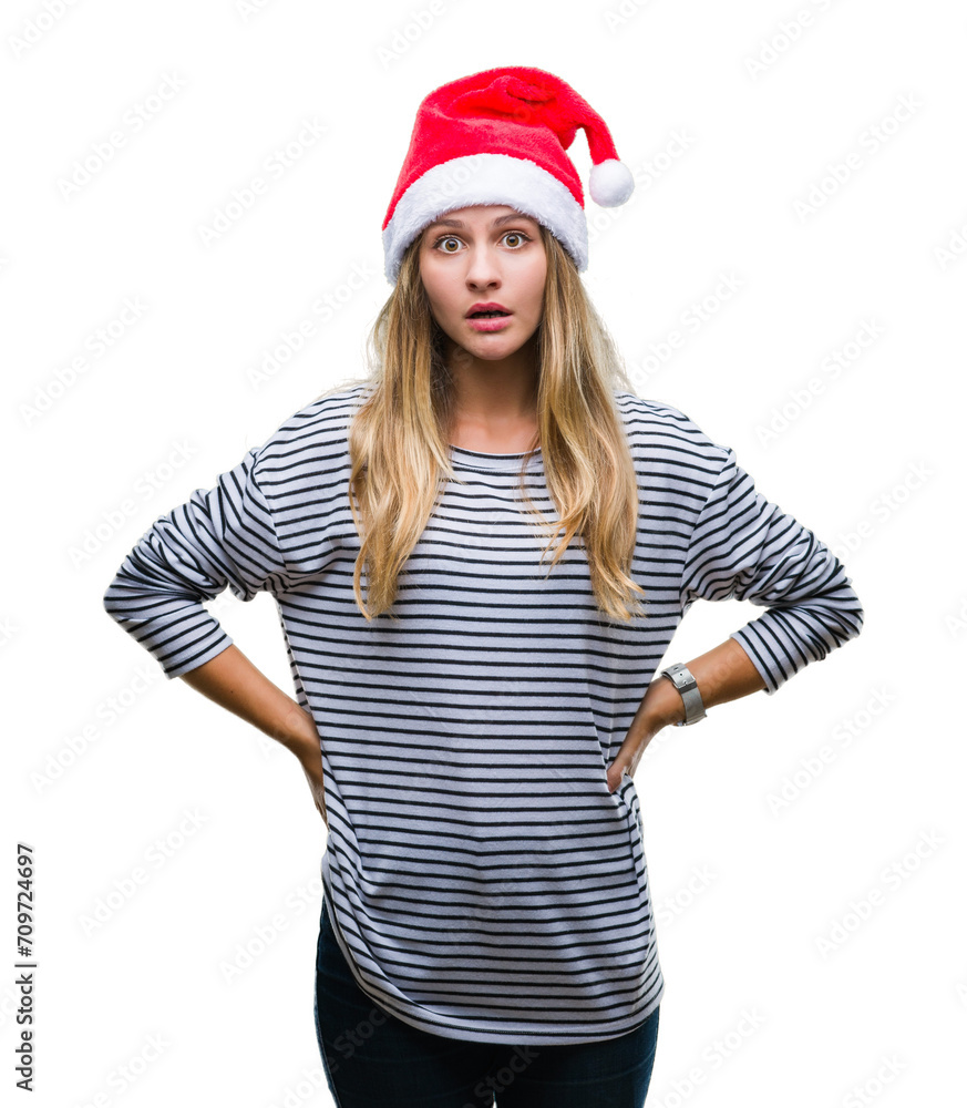 Young beautiful blonde woman wearing christmas hat over isolated background afraid and shocked with surprise expression, fear and excited face. Young beautiful blonde woman wearing christmas hat over isolated background afraid and shocked with surprise expression, fear and excited face.
