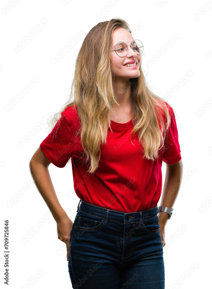 Young beautiful blonde woman wearing glasses over isolated background looking away to side with smile on face, natural expression. Laughing confident. Young beautiful blonde woman wearing glasses over isolated background looking away to side with smile on face, natural expression. Laughing confident.