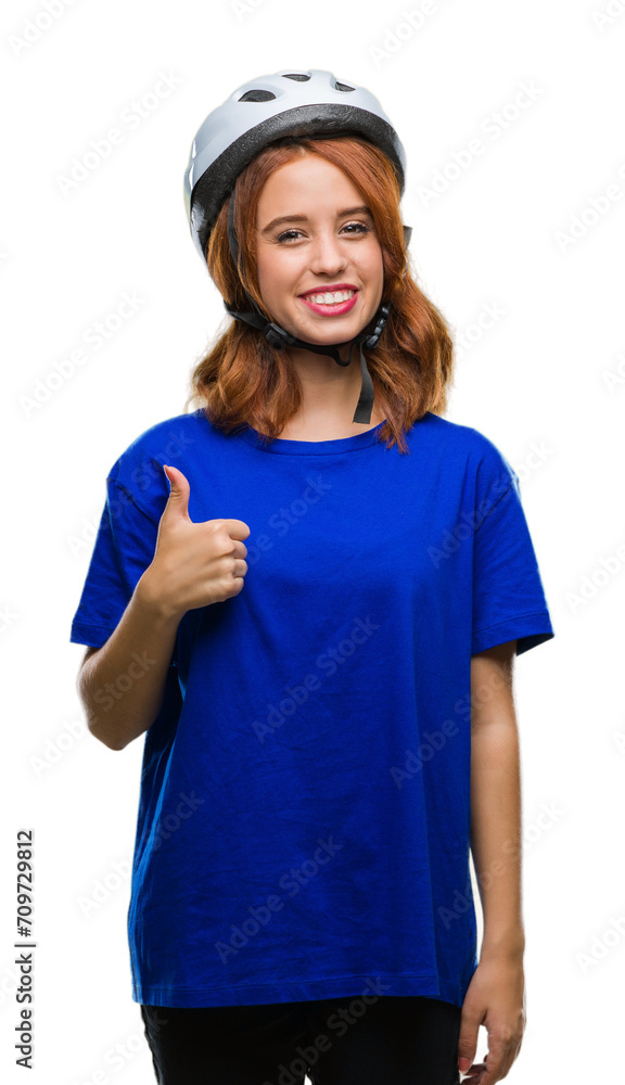 Young beautiful woman wearing cyclist helmet over isolated background doing happy thumbs up gesture with hand. Approving expression looking at the camera with showing success. Young beautiful woman wearing cyclist helmet over isolated background doing happy thumbs up gesture with hand. Approving expression looking at the camera with showing success.