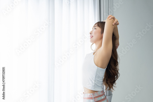日差しが入る窓際でストレッチをする女性