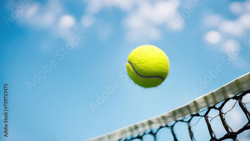 Yellow tennis ball and net on a blue sky background. Sport concept banner with copy space.Generative AI. © svf74