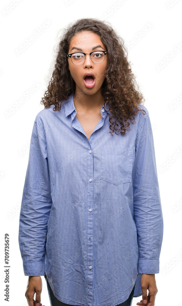 Beautiful young hispanic woman wearing glasses scared in shock with a surprise face, afraid and excited with fear expression Beautiful young hispanic woman wearing glasses scared in shock with a surprise face, afraid and excited with fear expression