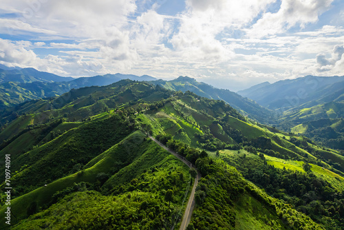 Aerial view of a road in the middle of the forest and road curve construction up to mountain.