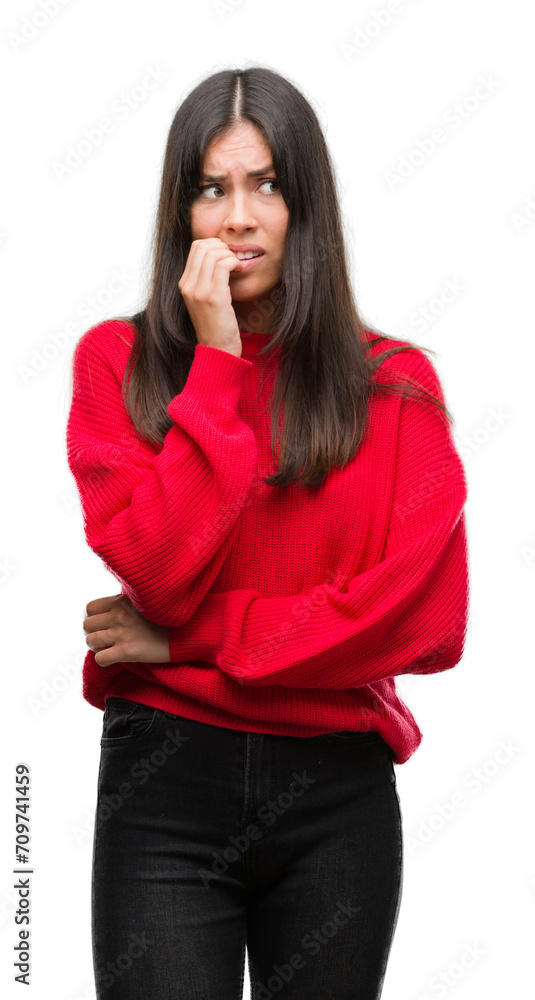 Young beautiful hispanic wearing red sweater looking stressed and nervous with hands on mouth biting nails. Anxiety problem. Young beautiful hispanic wearing red sweater looking stressed and nervous with hands on mouth biting nails. Anxiety problem.